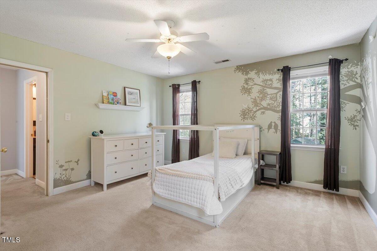 4725 Sinclair Drive Raleigh, NC 27616 - Photo 23 of 36 a bedroom with a large bed and a chandelier