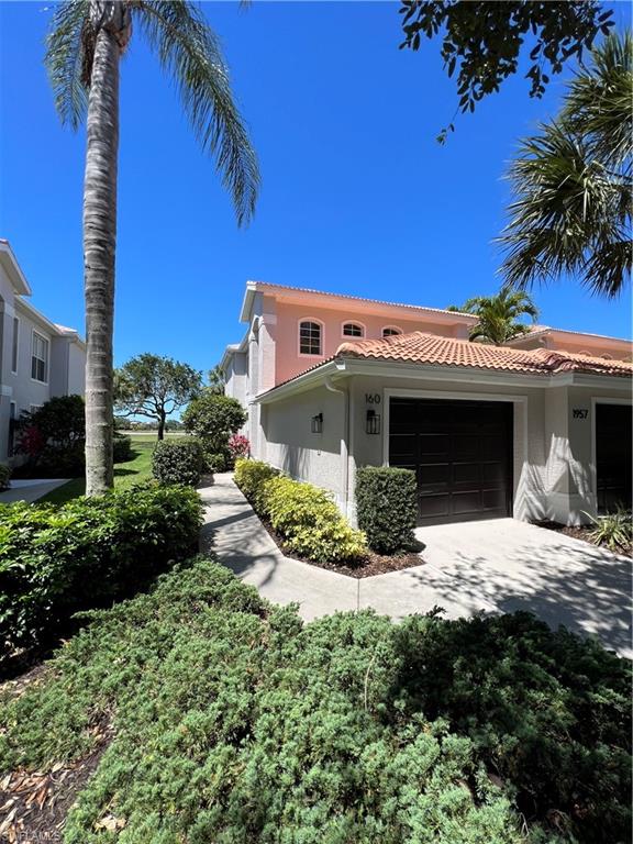 a view of a house with a yard and potted plants