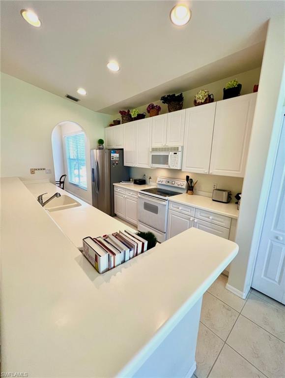 1957 Crestview Way, Unit 160 Naples, FL 34119 - Photo 12 of 32 a kitchen with stainless steel appliances a refrigerator sink and stove