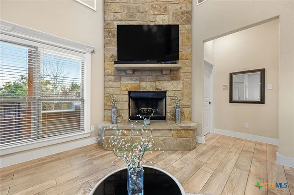 a living room with furniture a flat screen tv and a fireplace