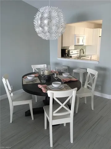 a dining room with furniture a chandelier and wooden floor