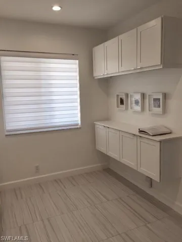 a view of a kitchen with wooden floor and cabinets