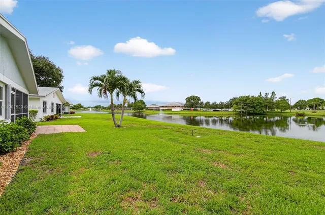 a front view of a house with a yard and potted plants