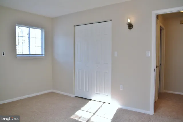 an empty room with windows and closet