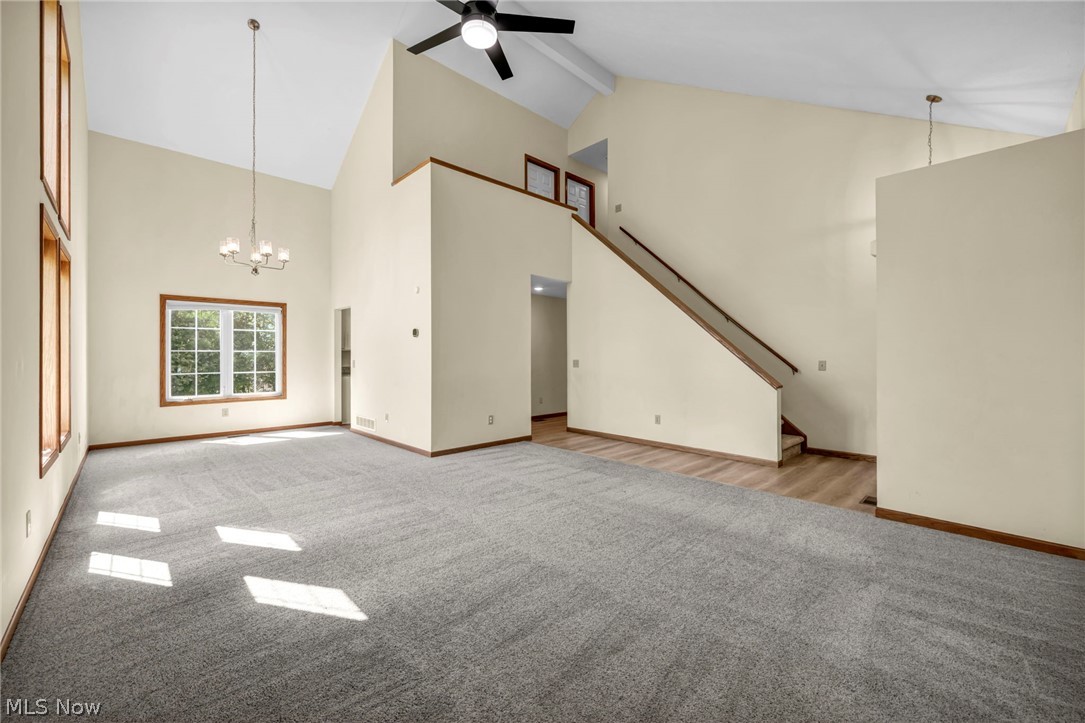 9842 Johnnycake Ridge Road Mentor, OH 44060 - Photo 6 of 40 Spacious room featuring vaulted ceilings, a prominent window with wood-frame trim, and an overhead chandelier