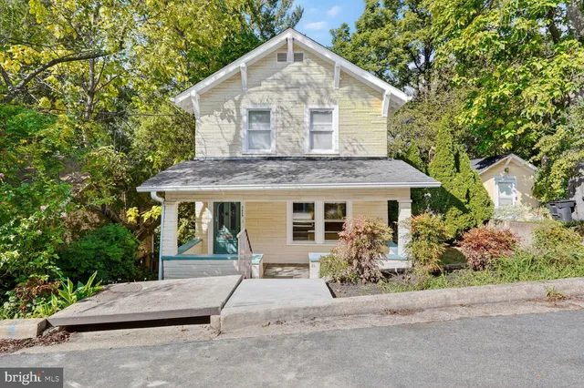 a view of a house with a yard and potted plants