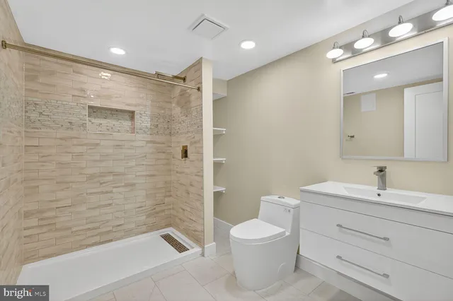 a bathroom with a toilet a sink a mirror and a bathtub