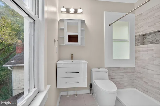 a bathroom with a sink a toilet and a window