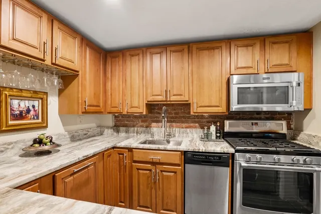 a kitchen with stainless steel appliances granite countertop a stove a sink and a microwave