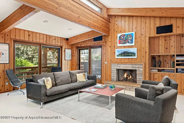 a living room with furniture a fireplace and a large window