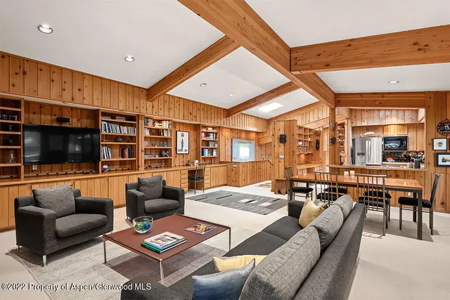 a living room with furniture kitchen view and a flat screen tv
