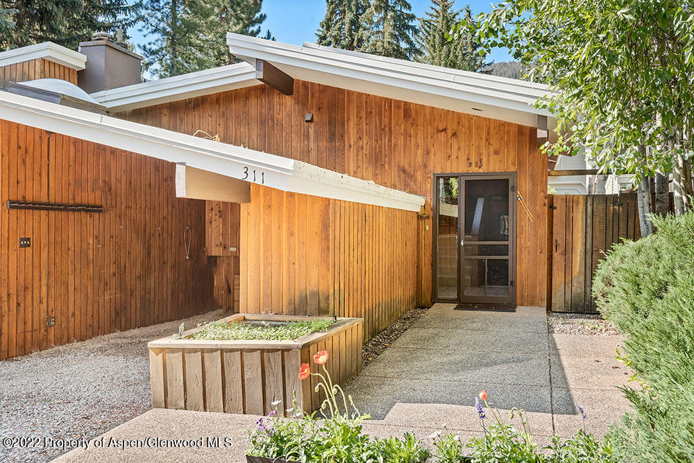 311 West North Street, Unit A Aspen, CO 81611 - Photo 38 of 39 a backyard of a house with large trees and plants