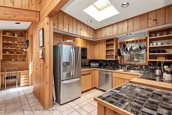 a kitchen with stainless steel appliances granite countertop a refrigerator a stove and a sink