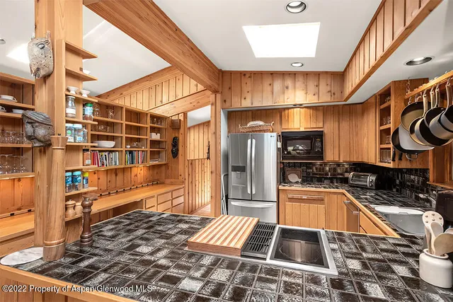 a kitchen with granite countertop a stove a sink and a microwave