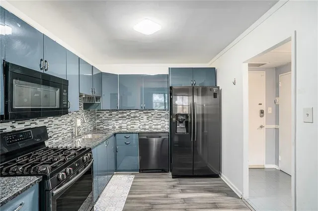 a kitchen with stainless steel appliances granite countertop a stove refrigerator and microwave