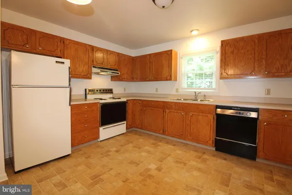 a kitchen with granite countertop a sink stainless steel appliances and cabinets