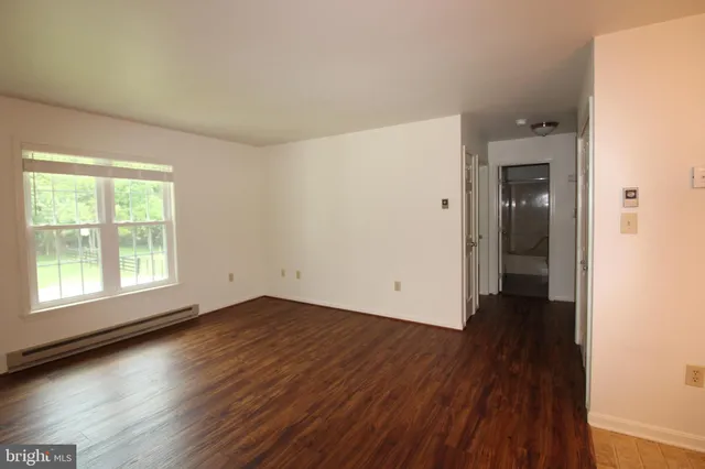 an empty room with wooden floor and a window