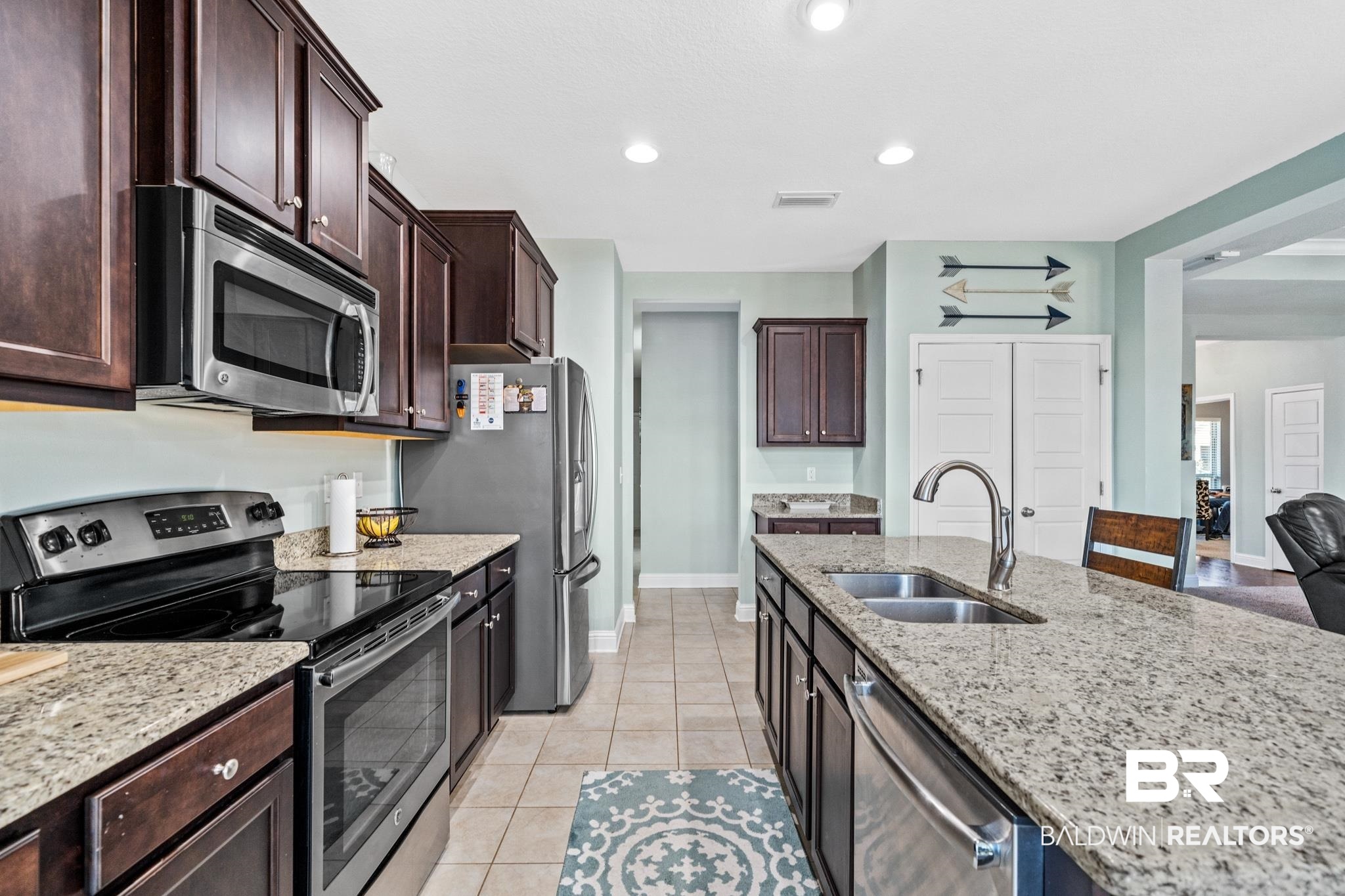 31472 Hoot Owl Road Daphne, AL 36527 - Photo 13 of 32 Kitchen with appliances with stainless steel finishes, light tile patterned floors, sink, and light stone countertops