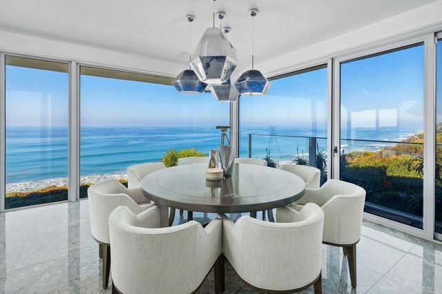 a living room with furniture and floor to ceiling windows