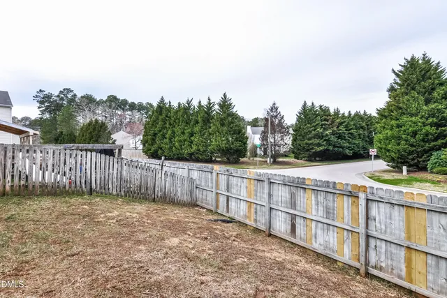a view of a fence and trees in the background