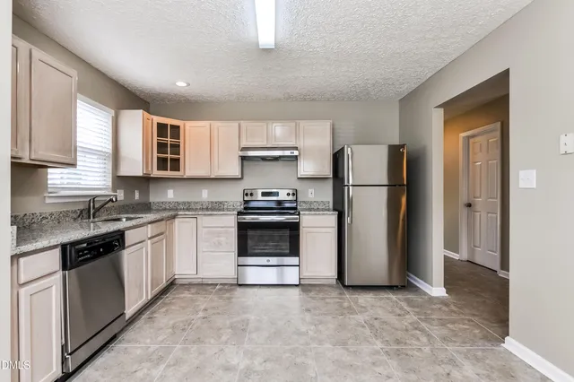 a kitchen with a refrigerator sink and stove top oven