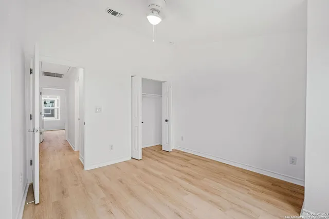 a view of a room with wooden floor and a bathroom