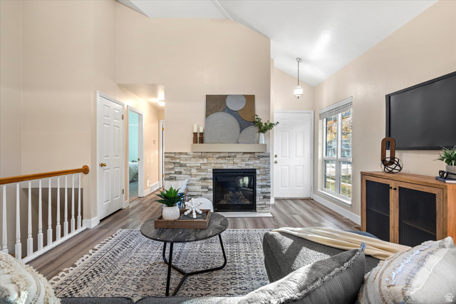888 East 6895 South Midvale, UT 84047 - Photo 8 of 54 Living area with wood finished floors, lofted ceiling, and a stone fireplace