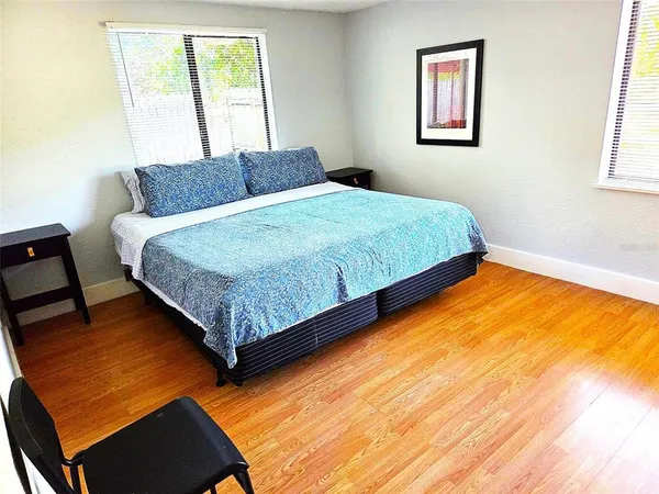 a bedroom with a bed rug and wooden floor