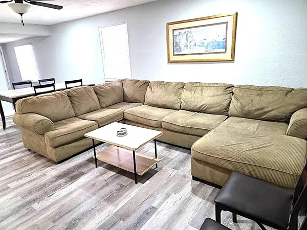 a living room with furniture and a wooden floor