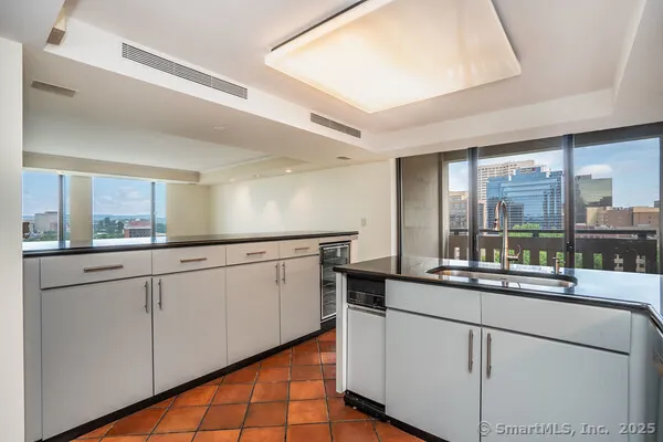a kitchen with white cabinets and sink