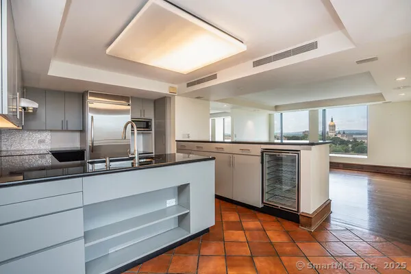 a kitchen with stainless steel appliances kitchen island granite countertop a sink cabinets and wooden floor