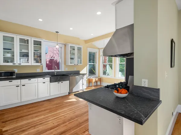 a kitchen with stainless steel appliances granite countertop a sink counter space and wooden floor
