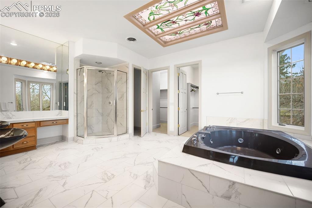 15 Mirada Road Colorado Springs, CO 80906 - Photo 27 of 50 Primary Bathroom with double sinks, vanity area and jetted tub with standing shower