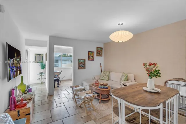 a living room with furniture a flat screen tv and a dining table