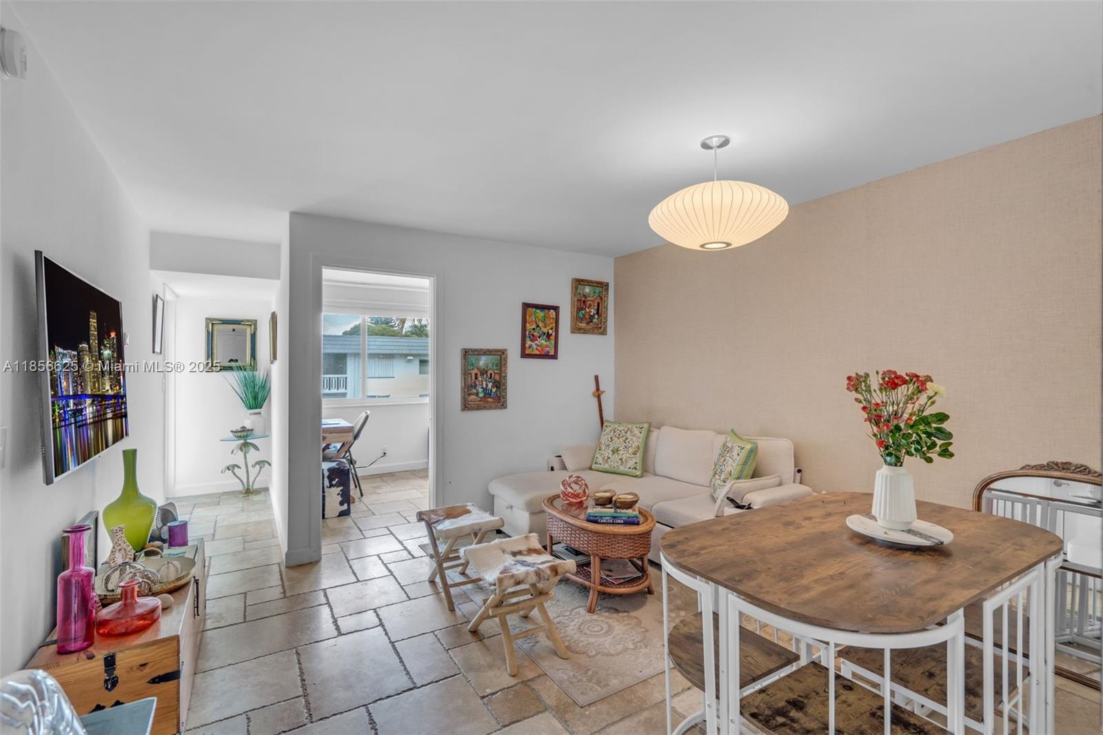 a living room with furniture a flat screen tv and a dining table