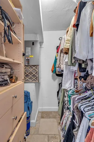 a view of walk in closet with clothes and shoes