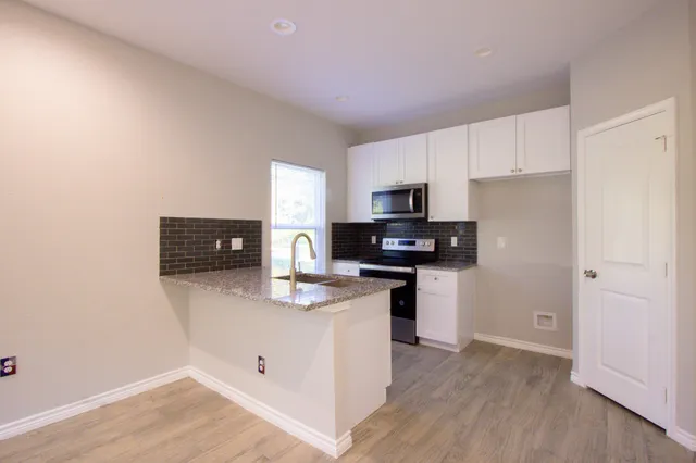 a kitchen with stainless steel appliances granite countertop a refrigerator stove microwave and sink