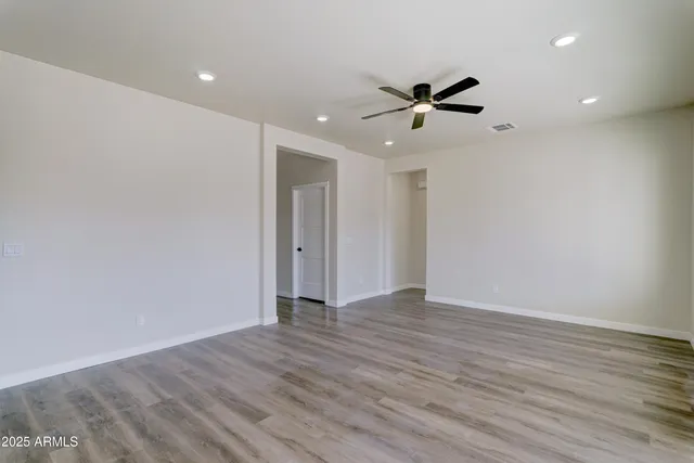 a view of an empty room with wooden floor