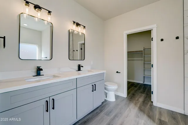 a bathroom with a double vanity sink toilet and a mirror