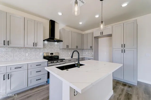 a kitchen with a white center island and stainless steel appliances