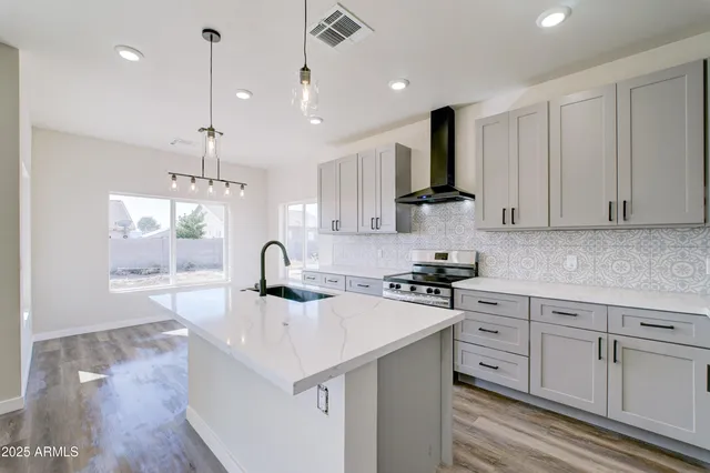 a kitchen with stainless steel appliances granite countertop a sink stove and refrigerator