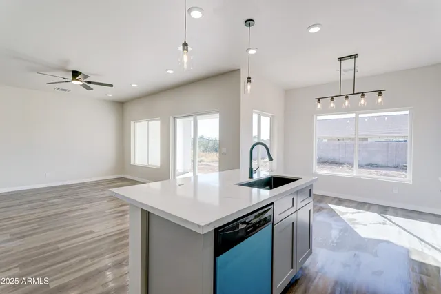 a kitchen with stainless steel appliances granite countertop a sink a stove and a wooden floor