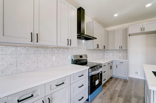 a kitchen with white cabinets and black appliances