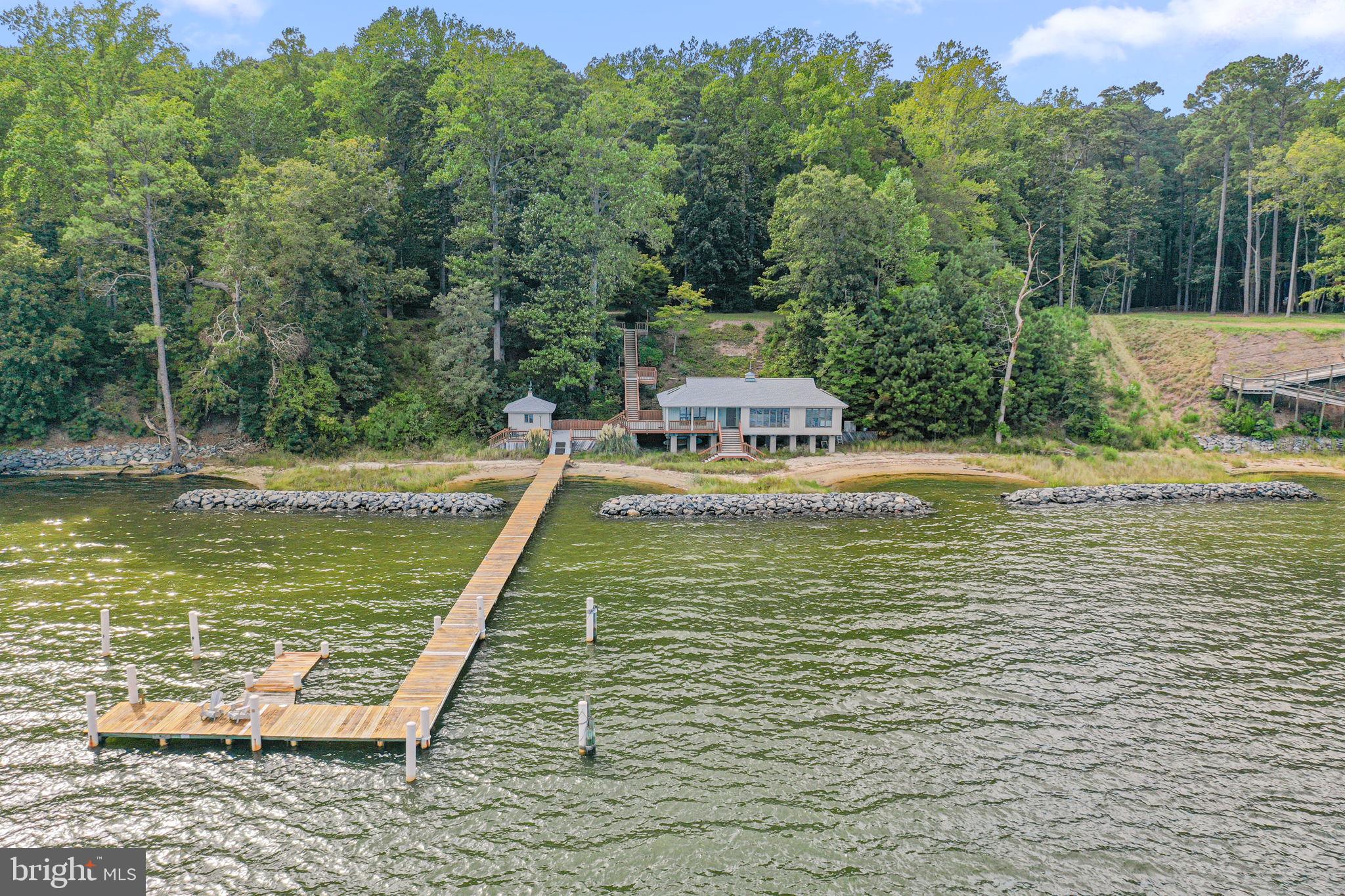 975 Wilton Creek Road Hartfield, VA 23071 - Photo 6 of 33 a view of a swimming pool with a bench and trees in the background