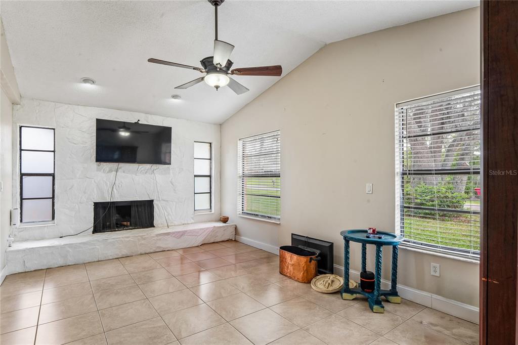 3112 Polk Avenue Spring Hill, FL 34609 - Photo 15 of 50 a living room with furniture a flat screen tv and a fireplace