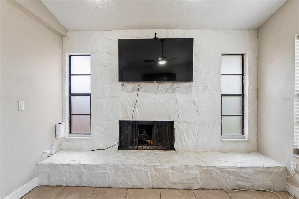 3112 Polk Avenue Spring Hill, FL 34609 - Photo 16 of 50 a living room with a fireplace and a flat screen tv