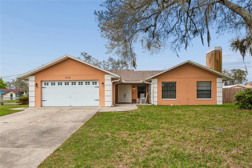 3112 Polk Avenue Spring Hill, FL 34609 - Photo 2 of 50 a view of a house with a yard and garage