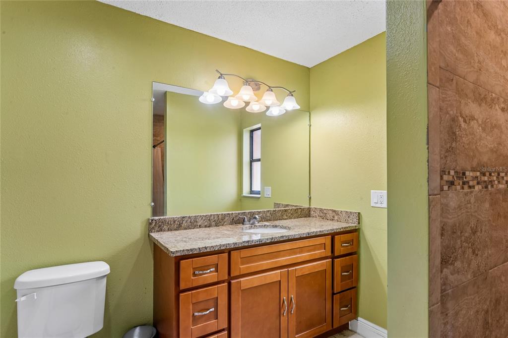 3112 Polk Avenue Spring Hill, FL 34609 - Photo 21 of 50 a bathroom with a granite countertop sink and a mirror