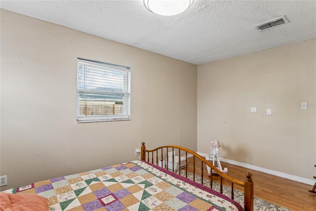 3112 Polk Avenue Spring Hill, FL 34609 - Photo 26 of 50 a bedroom with a bed next to a window