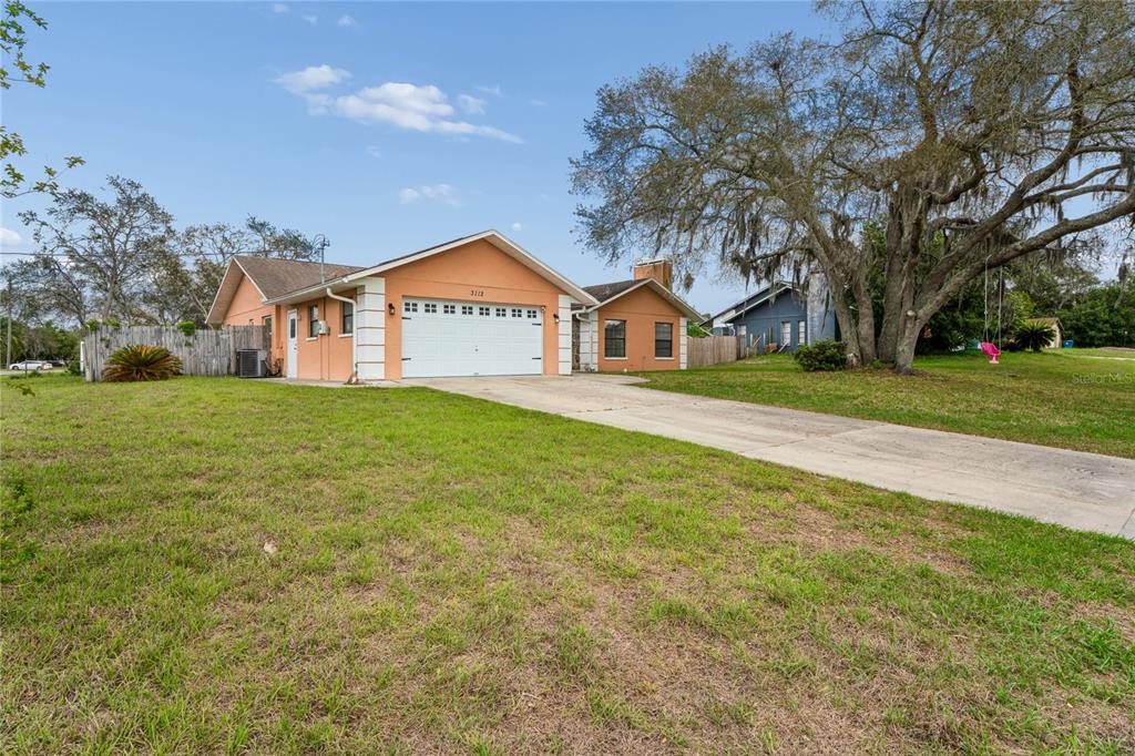 3112 Polk Avenue Spring Hill, FL 34609 - Photo 42 of 50 a front view of a house with a yard and garage
